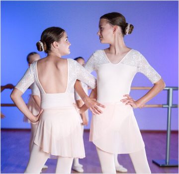 Ballett IV Kurs – Jugendliche Tänzerinnen in weißen Ballettkleidern im Studio